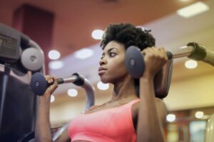 Determined woman performing a shoulder press exercise at the gym.
